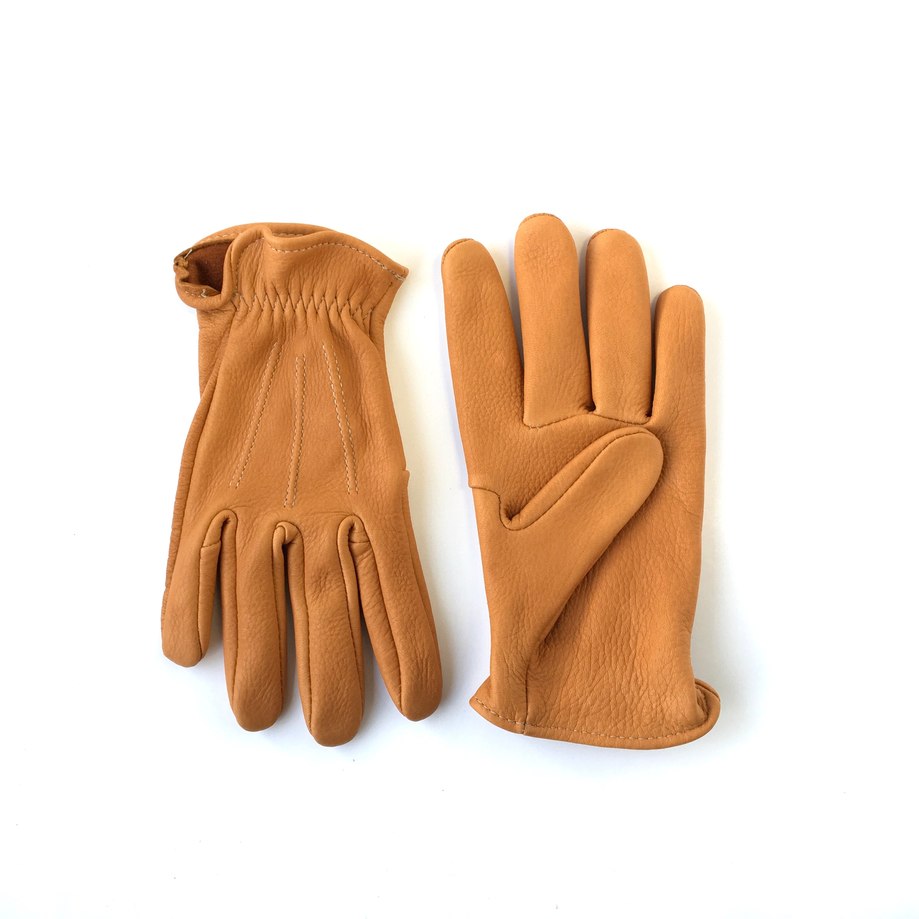 A pair of deerskin gloves short cuff with vintage stitch lines on the back saddle tan