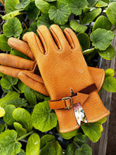 Load image into Gallery viewer, A pair of Elkskin gloves with fabric cuff laying on a bed of freshly planted lettuce