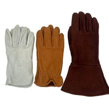 Load image into Gallery viewer, Three leather gloves laid flat on a white surface: one light gray, one tan/caramel, and one dark reddish brown.
