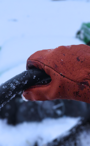 lined buffalo gloves in the snow on a tractor - USA made bison leather gloves lined riding tractor