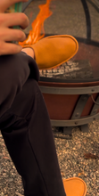 Load image into Gallery viewer, Man wearing tan elk skin slippers sitting by a fire