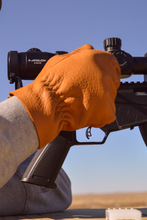 Load image into Gallery viewer, Man siting in his gun at a table wearing upland shooting gloves made with deerskin